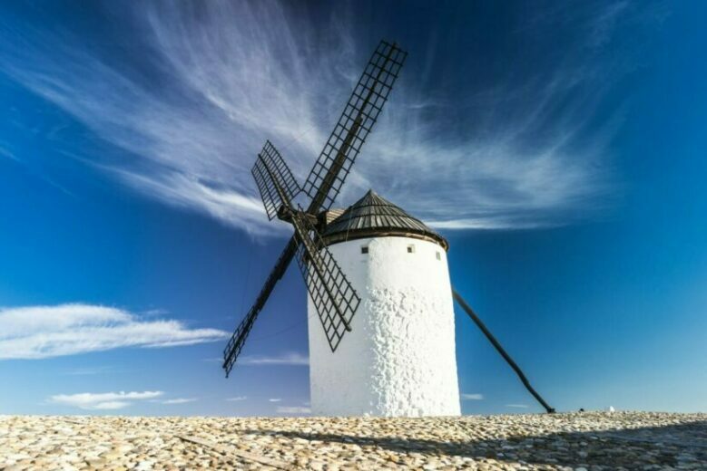 Eine Windmühle steht auf einem freien Land.
