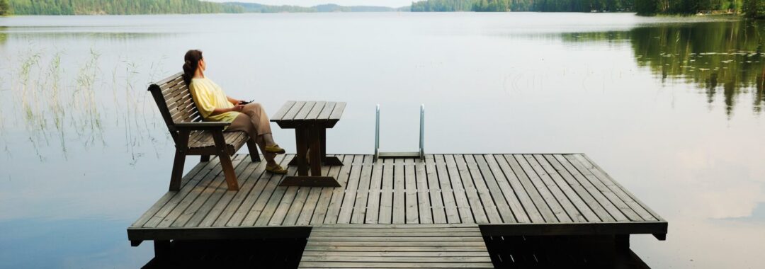Frau am See blickt in die Ferne – innere Ruhe und Energiearbeit