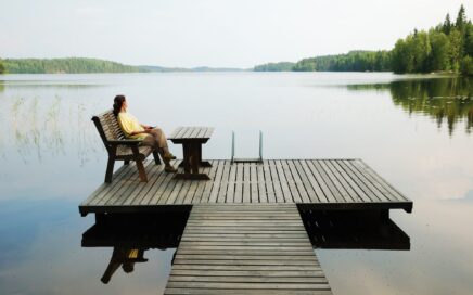 Frau am See blickt in die Ferne – innere Ruhe und Energiearbeit