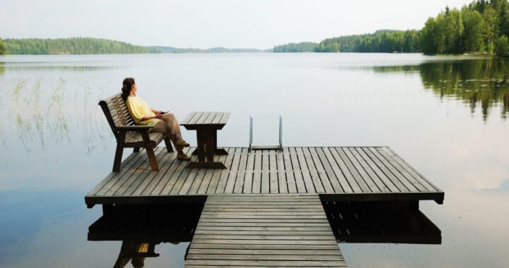 Frau am See blickt in die Ferne – innere Ruhe und Energiearbeit