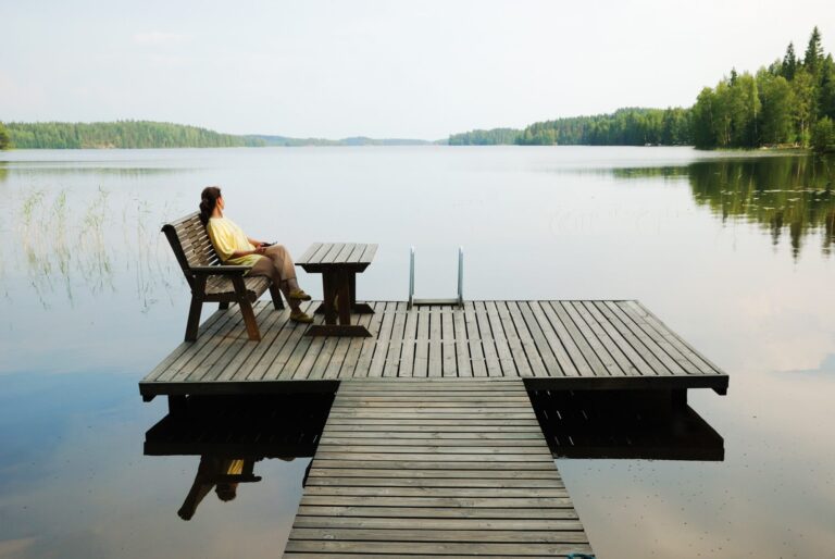 Frau am See blickt in die Ferne – innere Ruhe und Energiearbeit