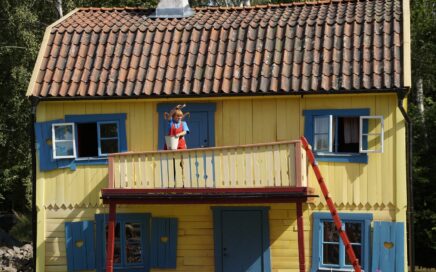 Pippi Langstrumpf steht auf dem Balkon der Villa Kunterbunt
